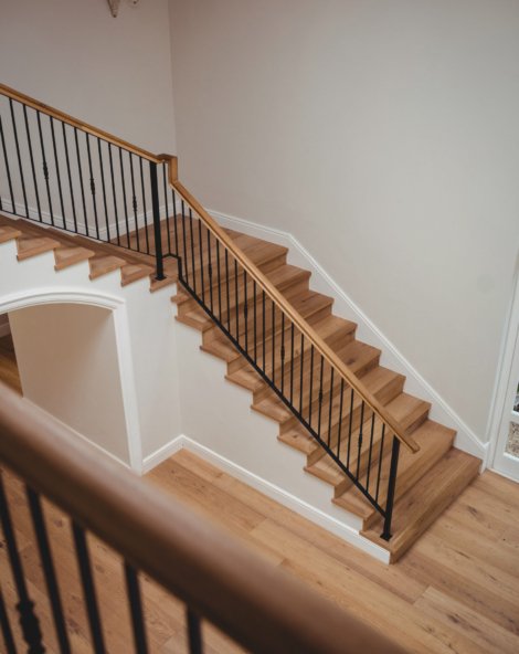 Interior of home with wooden floor and staircase with white walls