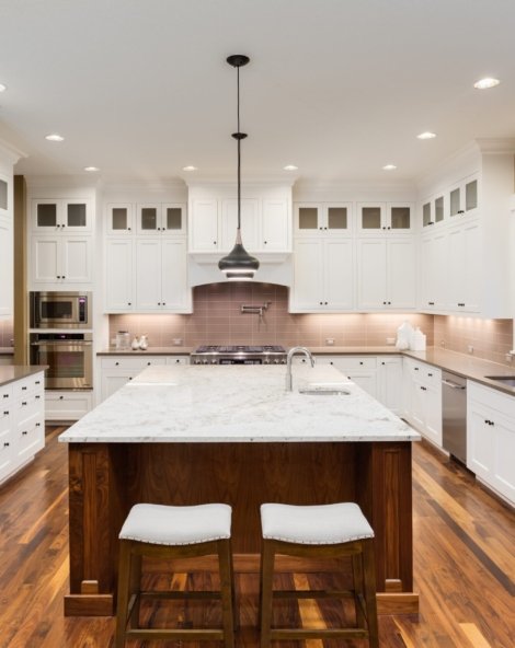 Kitchen Interior with Island, Hardwood Floors, and Pendand Lights in New Luxury Home